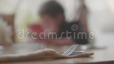 少年在咖啡馆里吃饭，背景模糊，慢动作视频快餐。 咖啡馆里人们的快餐概念